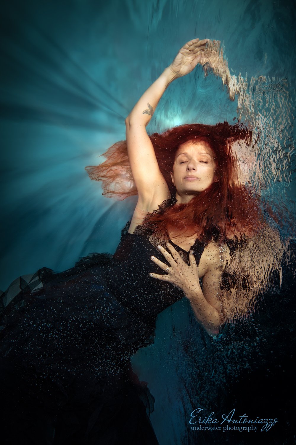 Onderwaterfoto model jonge vrouw met rood haar in mooie jurk