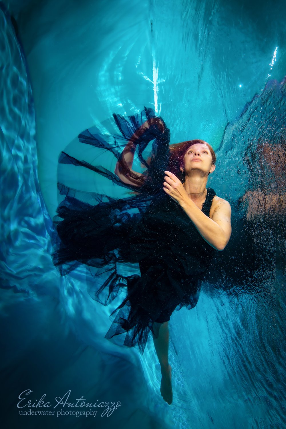 Onderwaterfoto model jonge vrouw met rood haar in mooie jurk