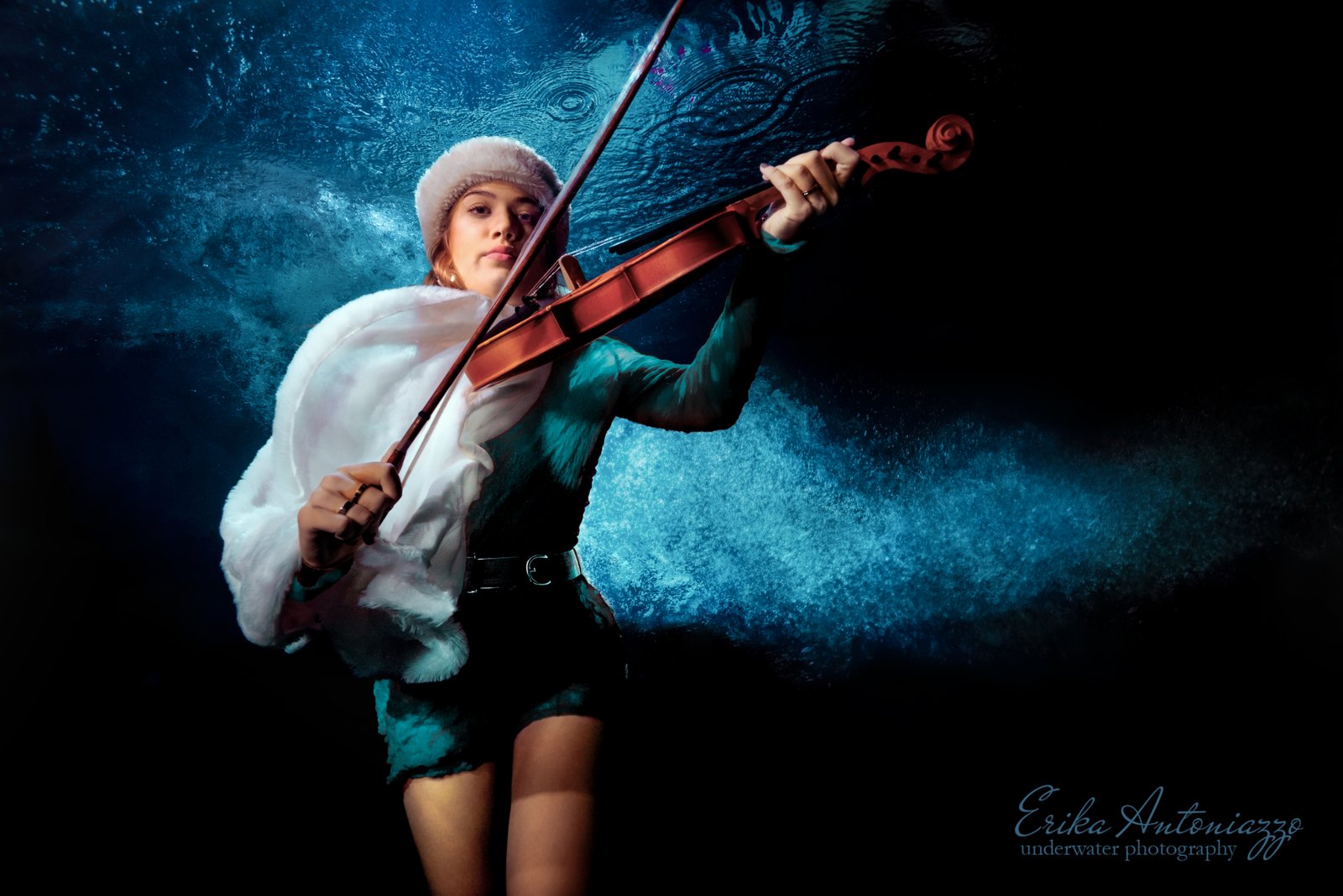 Onderwaterfoto model jonge vrouw groen jurkje met kozakkenmuts en cape, met viool