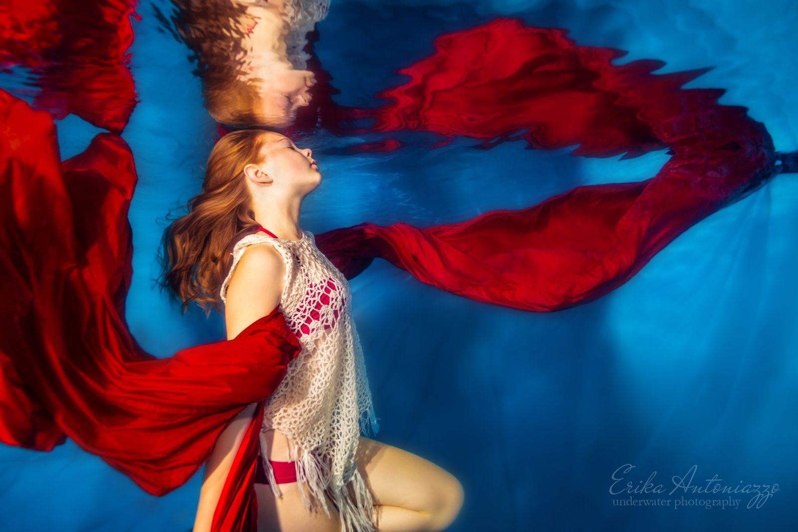 Onderwaterfoto model, jonge vrouw met rode sluier