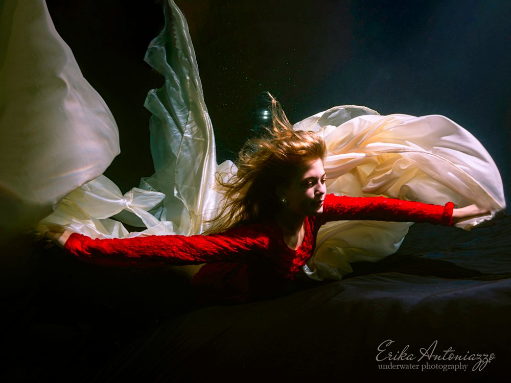 Onderwaterfoto model, jonge vrouw met rode jurk en witte sluier