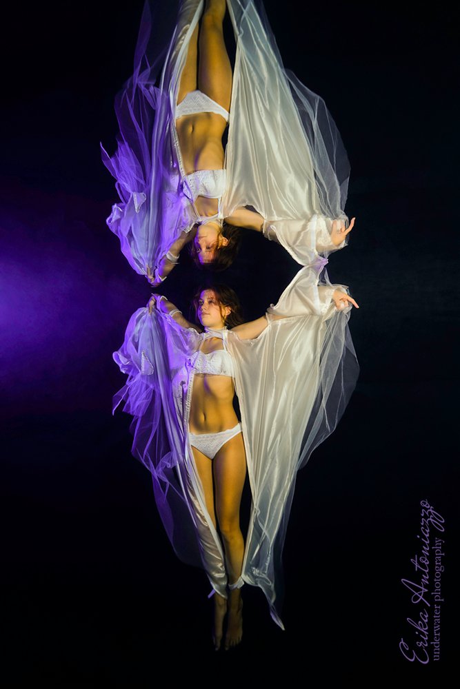 Onderwaterfoto model, jonge vrouw met witte sluiers aan armen en benen