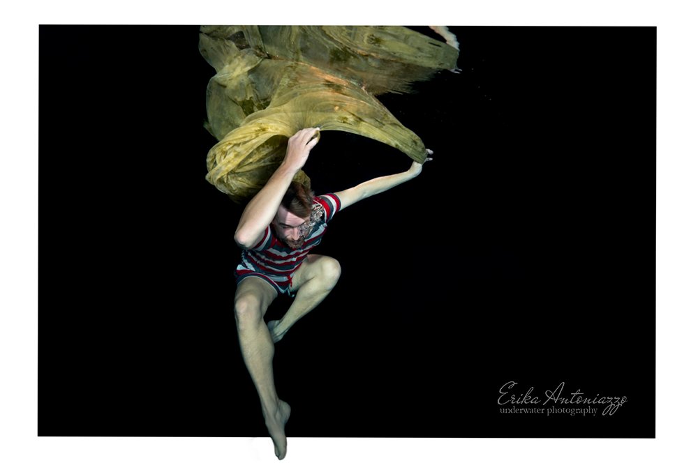 Onderwaterfoto model, man in gestreepte kleding met gele doek boven het hoofd en weerspiegeling