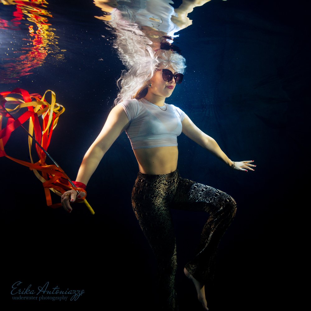 Onderwaterfoto model, jonge vrouw in wit topje en glitterbroek